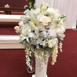 White floral arrangement in a tall pedestal vase