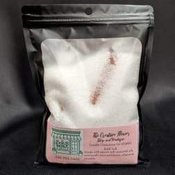 Bag of white bath salts with a pink label