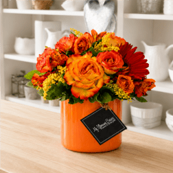 Orange and red rose bouquet in an orange vase