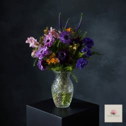 Purple and pink mixed bouquet in a clear glass vase