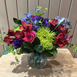 Colorful bouquet in a clear glass vase with roses, chrysanthemums, and alstroemeria