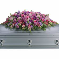 Pink and purple floral spray on a silver casket