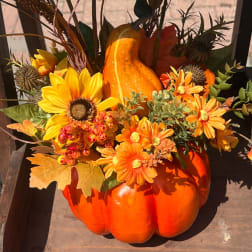 Orange pumpkin arrangement with yellow and orange flowers