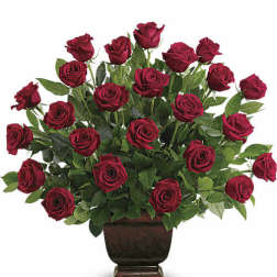 Red roses arranged in a dark pedestal vase
