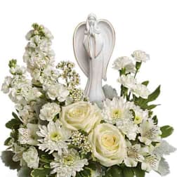White floral arrangement with angel figurine centerpiece