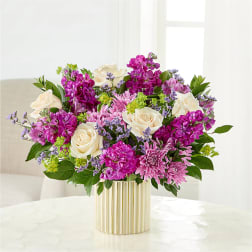 Pink and white flower arrangement in a striped gold vase