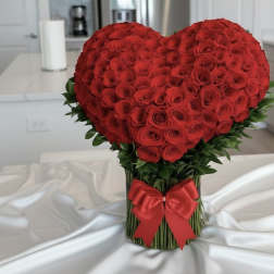 Heart-shaped bouquet of red roses with a red ribbon