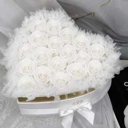 Round bouquet of white roses wrapped in sheer white tulle