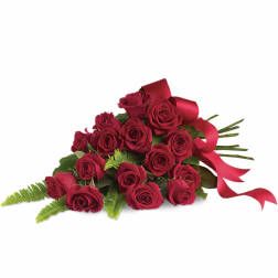 Tied bundle of long-stem red roses with fern accents and red ribbon.