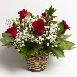 Red roses and baby's breath in a woven basket