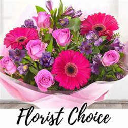 Pink and purple bouquet with gerbera daisies and roses wrapped in pale pink paper
