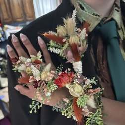Floral wrist corsage and matching boutonniere with dried blooms and ribbon