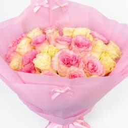 Pink and pale yellow roses wrapped in pink paper with ribbon bows