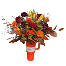 Bouquet of red, orange, and purple flowers in an orange tumbler