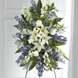 Tall standing floral spray with white lilies and blue flowers