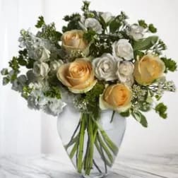 Bouquet of cream and white roses in a clear glass vase