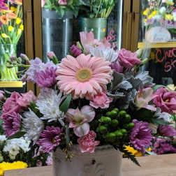 Pink and white mixed flower arrangement in a white ceramic container