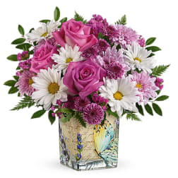 Pink roses and white daisies in a decorative glass vase