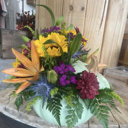Mixed bouquet in a mint pumpkin-shaped container with sunflowers and lilies