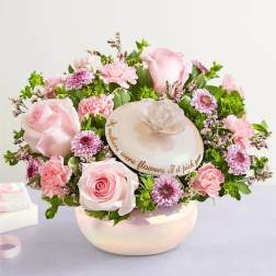 Pink roses and daisies arranged in a round hatbox with a decorative lid
