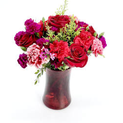 Red and pink bouquet in a burgundy glass vase