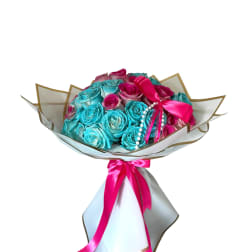 Bouquet of turquoise and pink roses wrapped in white paper with a pink ribbon