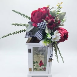 Red floral arrangement with white daisies in a white lantern box