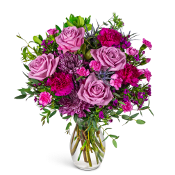 Pink and purple rose bouquet in a clear glass vase