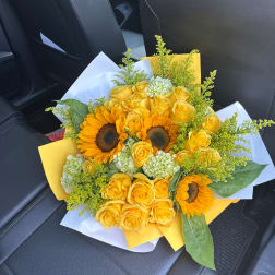 Yellow roses and sunflowers wrapped in white and yellow paper