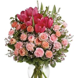 Pink tulips and peach roses in a clear glass vase