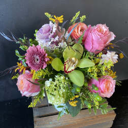 Pink roses and mixed blooms in a wooden box arrangement