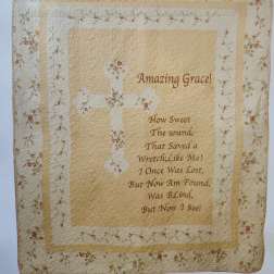 Quilted wall hanging with floral border and the words Amazing Grace