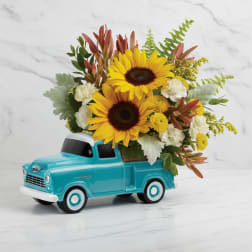 Sunflowers arranged in a turquoise toy truck