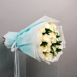 Bouquet of cream roses wrapped in pale blue paper