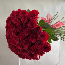 Large bouquet of red roses with pink ribbon accents