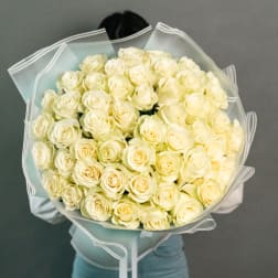 Large bouquet of cream-white roses wrapped in translucent paper