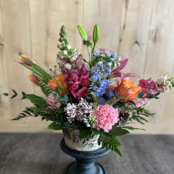 Colorful mixed flower arrangement in a pedestal vase