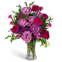 Pink roses and magenta carnations in a clear glass vase