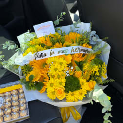 Yellow bouquet with daisies and roses, wrapped in white paper with a ribbon