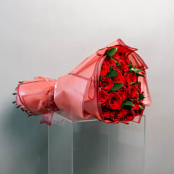 Bouquet of red roses wrapped in pink paper
