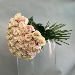 Large bouquet of pale pink roses with ribbon on a clear stand