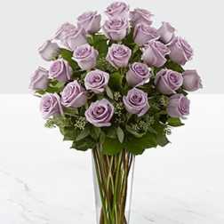 Lavender roses arranged in a clear glass vase