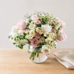 Pink and white roses arranged in a clear glass vase