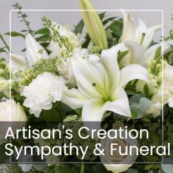 White lilies and roses arranged with greenery in a sympathy bouquet
