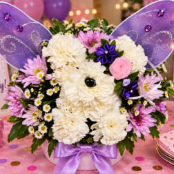 Purple fairy-themed flower arrangement with white carnations and pink daisies