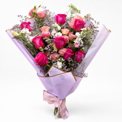 Bouquet of pink and white roses wrapped in lavender paper