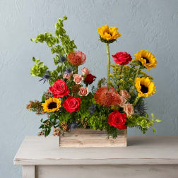 Mixed bouquet in a wooden box with roses and sunflowers