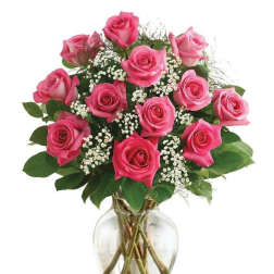 Pink roses arranged in a clear glass vase with white filler flowers