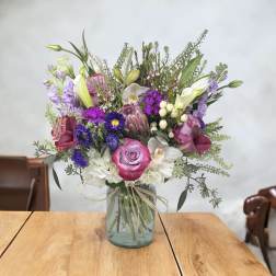 Mixed bouquet in a glass vase with pink, purple, white, and green flowers