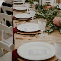 Wedding table setting with pink floral centerpieces and greenery